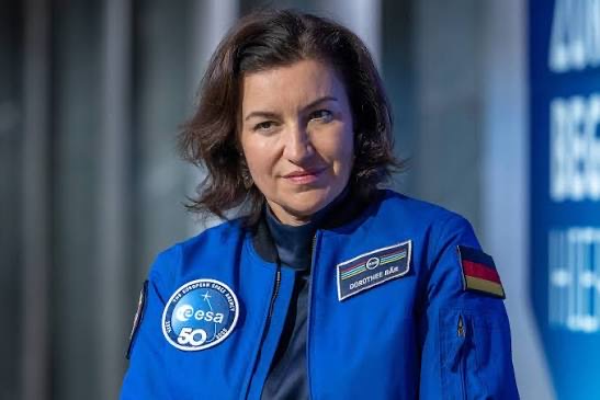 Dorothee Bär wearing a blue ESA flight jacket with her name badge and the German flag