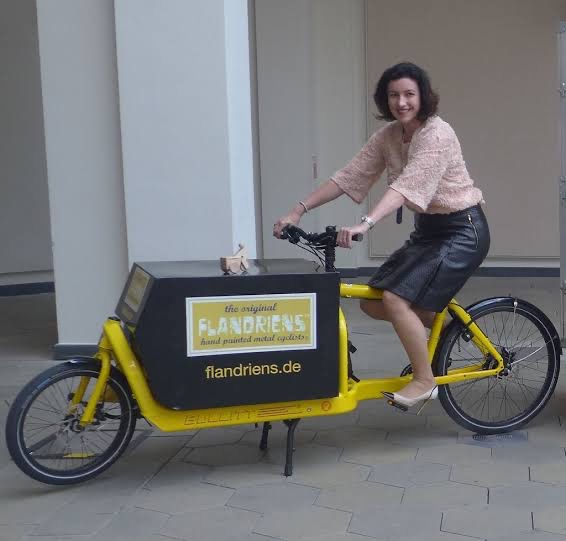 Dorothee Bär riding a yellow electric cargo bike